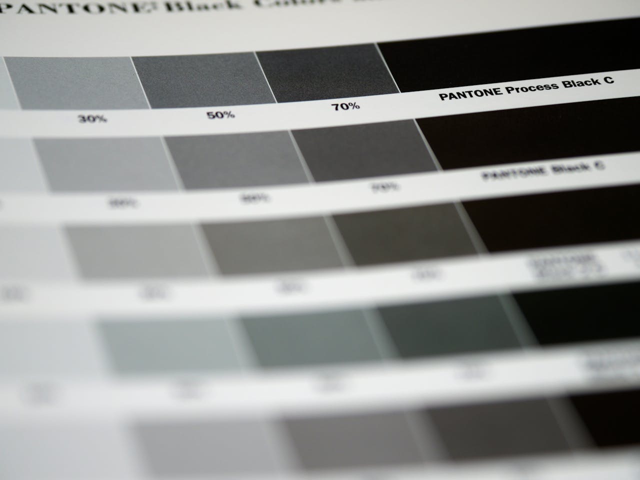 The Art of Drawing Readers In: Your attractive post title goes here Detailed close-up of Pantone black color swatches, featuring various shades and percentages.